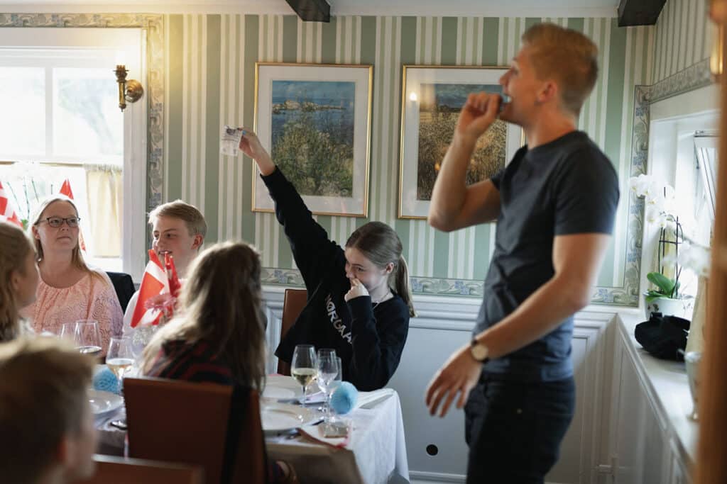 A young guest holding up a playing card during Anders Andresen’s magic show at a confirmation celebration