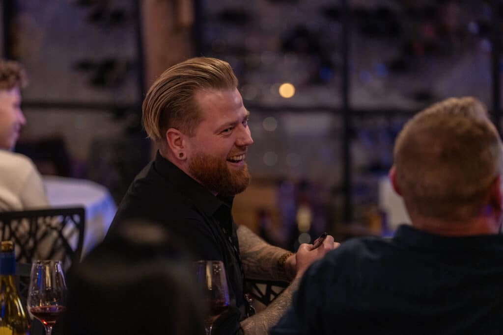Anders Andresen smiler blandt gæsterne ved bordene