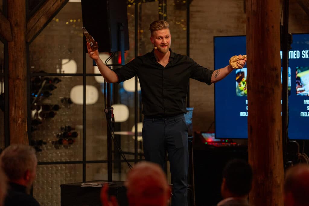 Anders Andresen performing on stage at a corporate event